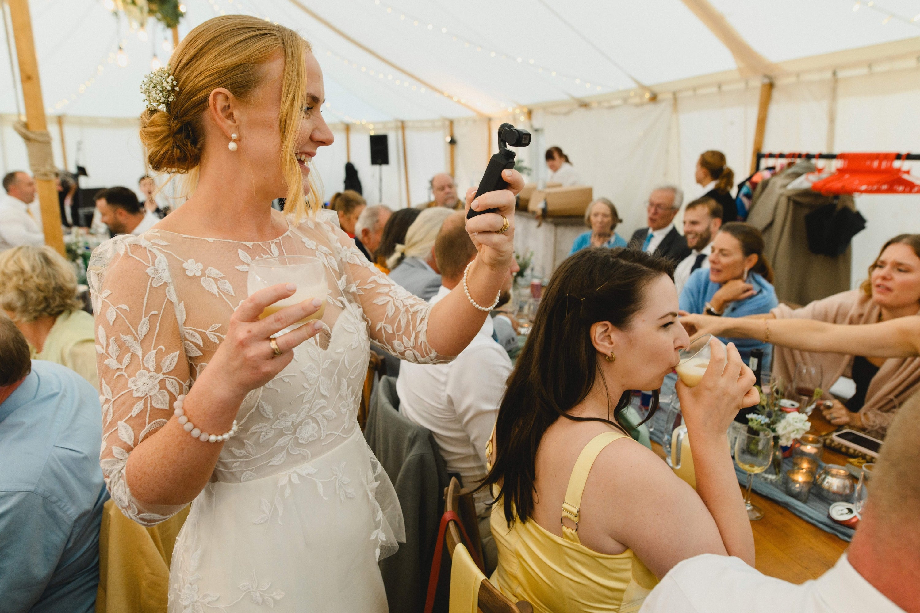 A wedding guest filming with a camera from Edit Your Wedding